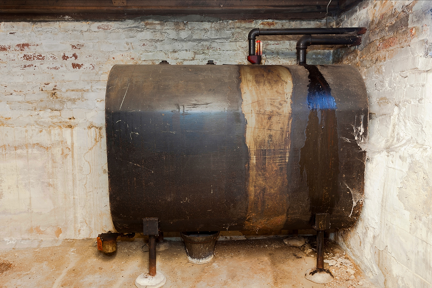 Old heating oil tank in dingy dank basement.